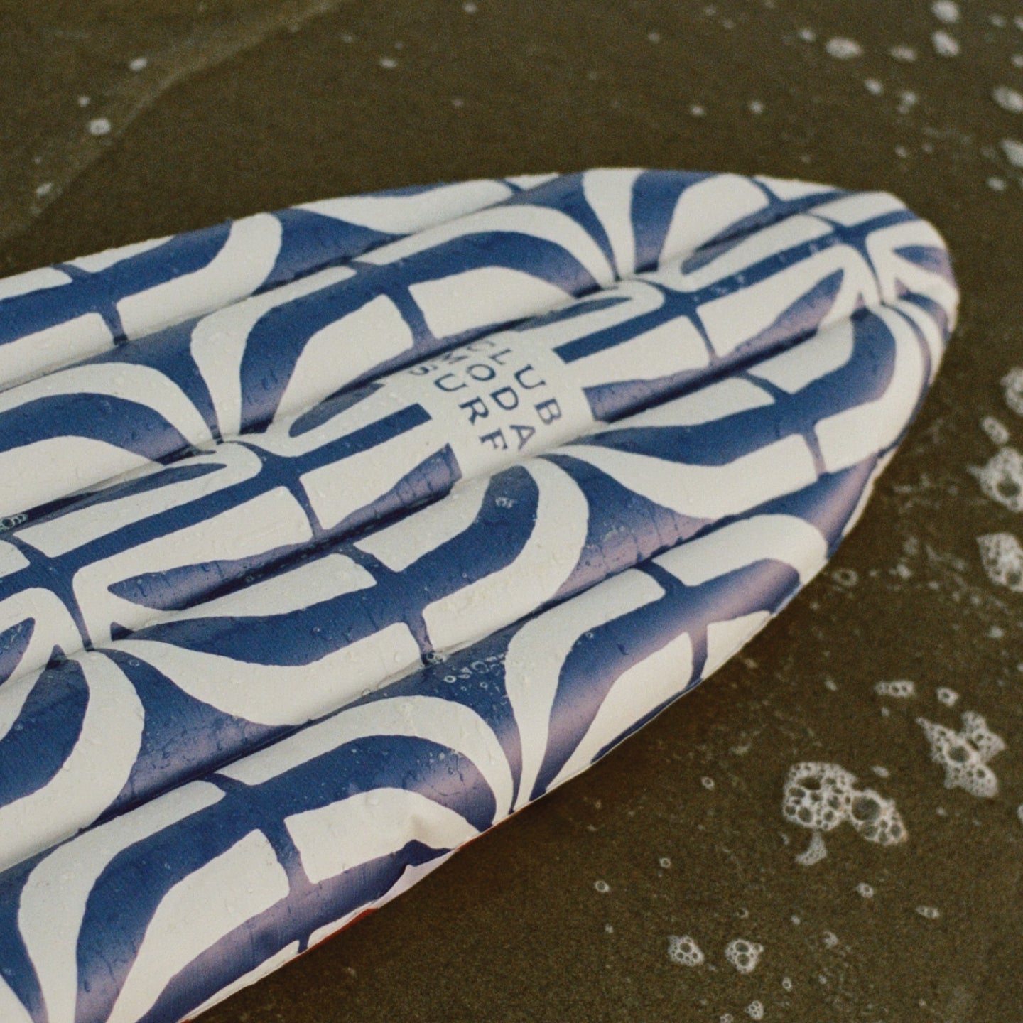 Funboy x Moda Operandi Club Moda Surfboard Pool Float. At the beach in the water.